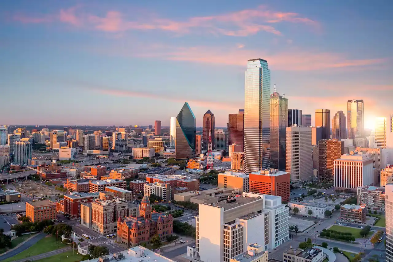 Skyline de Downtown Dallas al atardecer con rascacielos iluminados